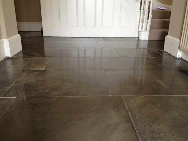 Polished blue lias flagstone floor repaired in a hallway 