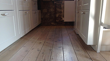 An old Victorian pine floor after lime washing in a kitchen 
